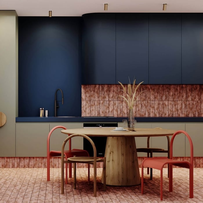 Eclectic kitchen with navy cabinets, copper backsplash, and a central wood table surrounded by red and curved-back chairs.