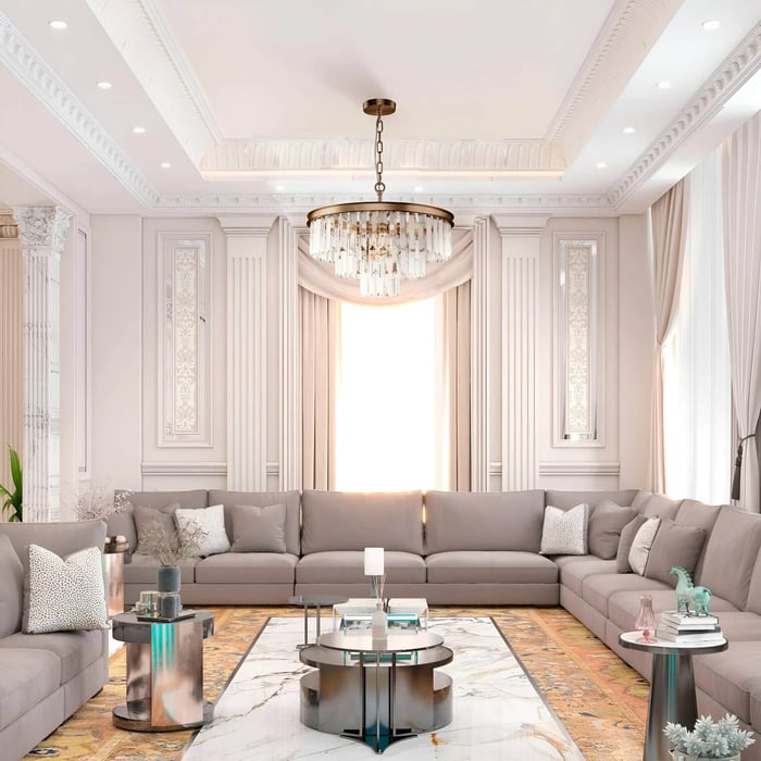 Luxury crystal chandelier suspended in a formal living room with symmetrical seating, decorative wall panelling, and a bright central window.
