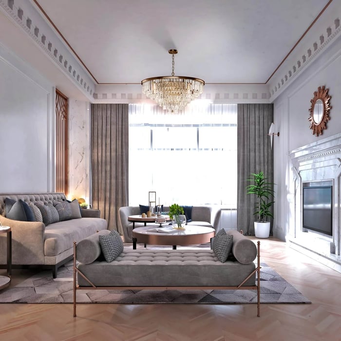 Elegant crystal chandelier centred in a classic living room with ornate ceiling details, soft grey seating, and floor-to-ceiling curtains.