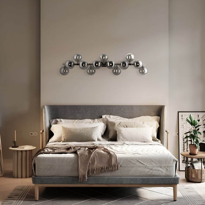 Unique wall light fixture with metallic globe bulbs mounted above a contemporary bed.