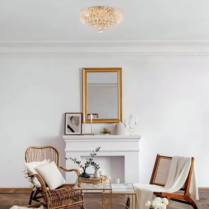 Minimal sitting area with rattan chairs, white fireplace, and gold crystal flush mount light.