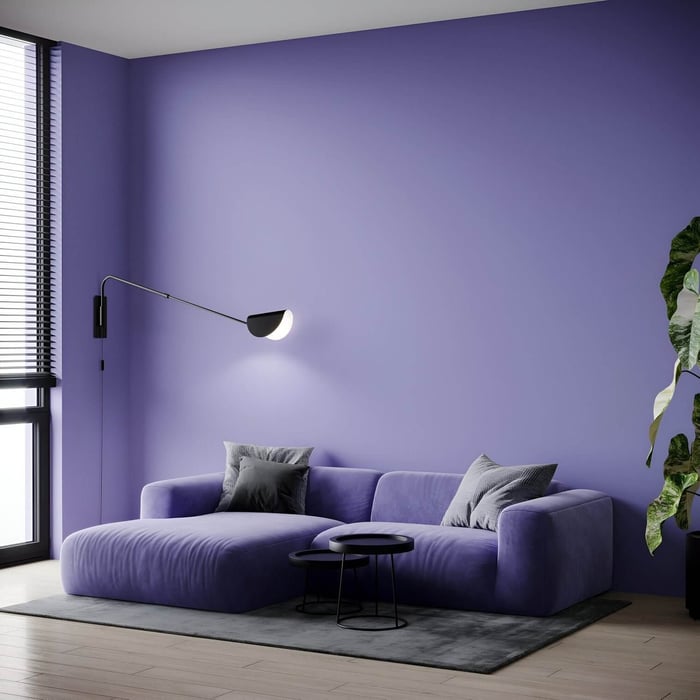 Minimalist living room with purple sectional sofa, matching wall, black swing-arm wall lamp, and nested black side tables on grey rug.