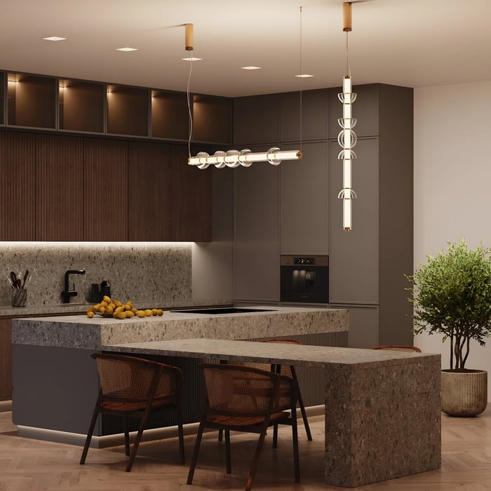 Modern kitchen with minimalist lighting, featuring two pendant lights with cylindrical glass elements over a stone kitchen island.