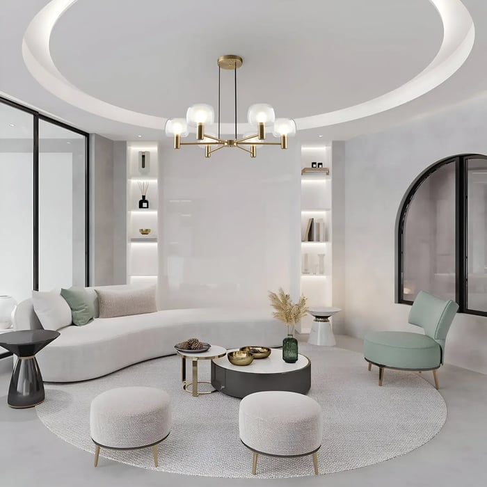 A living room setting featuring a hanging pendant light with decorative discs, positioned over a small wooden coffee table and surrounded by patterned armchairs.