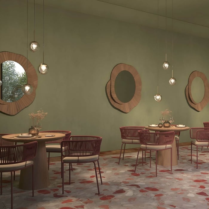 Contemporary café interior with round mirrors, globe pendant lights, and terrazzo flooring.