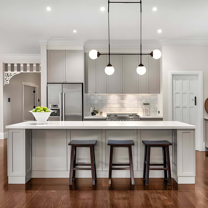 Transitional kitchen with pendant lights featuring globe bulbs over a white island and classic shaker cabinetry.