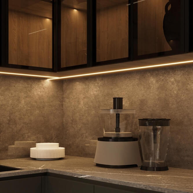Kitchen worktop with under-cabinet LED strip lighting along the backsplash, creating an even, glare-controlled light for food prep.
