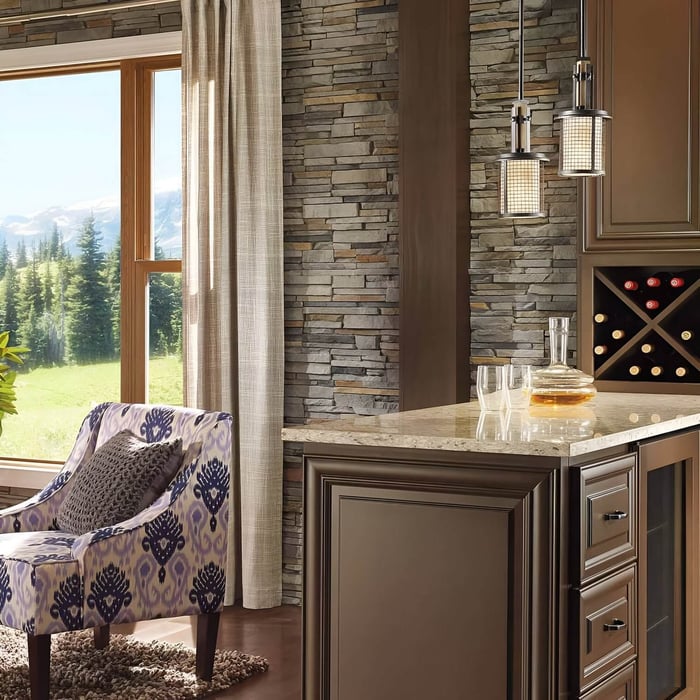 Rustic bar nook with stone walls, hanging pendant lights, and patterned accent chair.