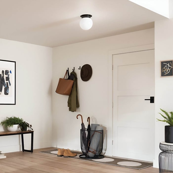Entryway ceiling light — Simple entryway with coat hooks, a bench, and a black-and-white flush-mount globe ceiling light.