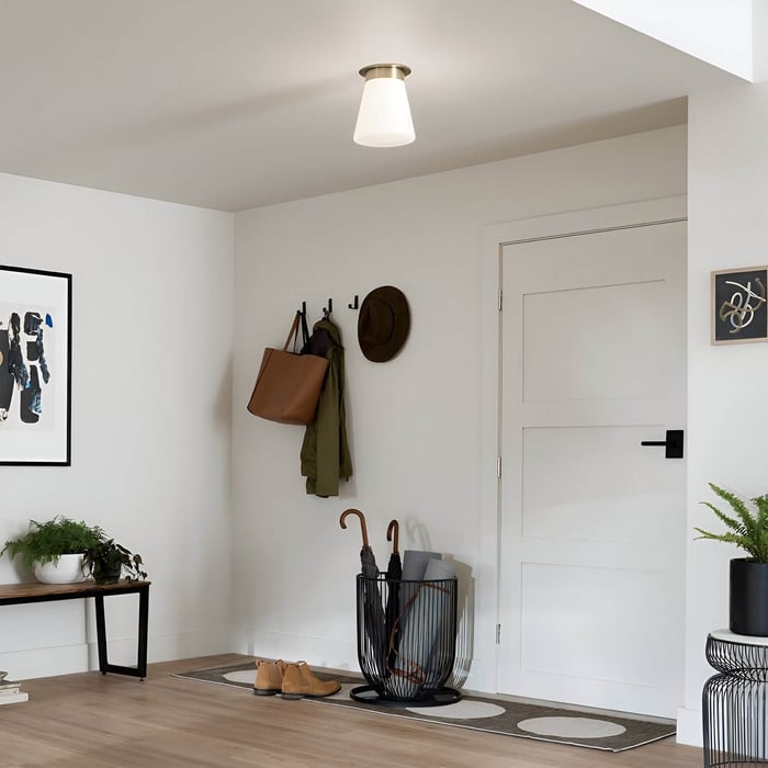 Entryway with white door, coat hooks, and conical semi-flush ceiling light.