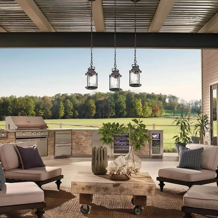Covered outdoor kitchen patio with three hanging lantern pendant lights above seating.