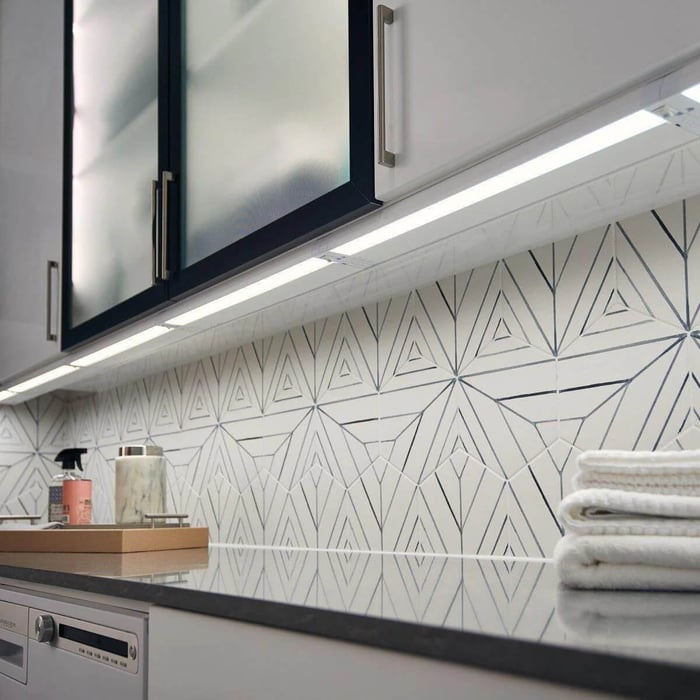 Under-cabinet LED strip lighting in a utility or laundry space, brightening the countertop area.