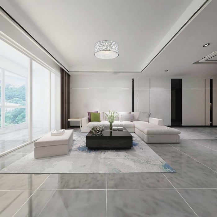 Spacious modern living room with large glass windows, a sectional white sofa, glossy gray floor tiles, and a crystal flush mount ceiling light.