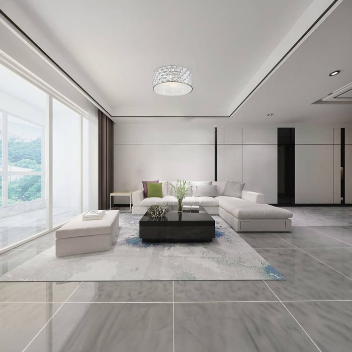Bright modern living room with a white sectional, tiled floors, large windows, and a crystal flush mount ceiling light.