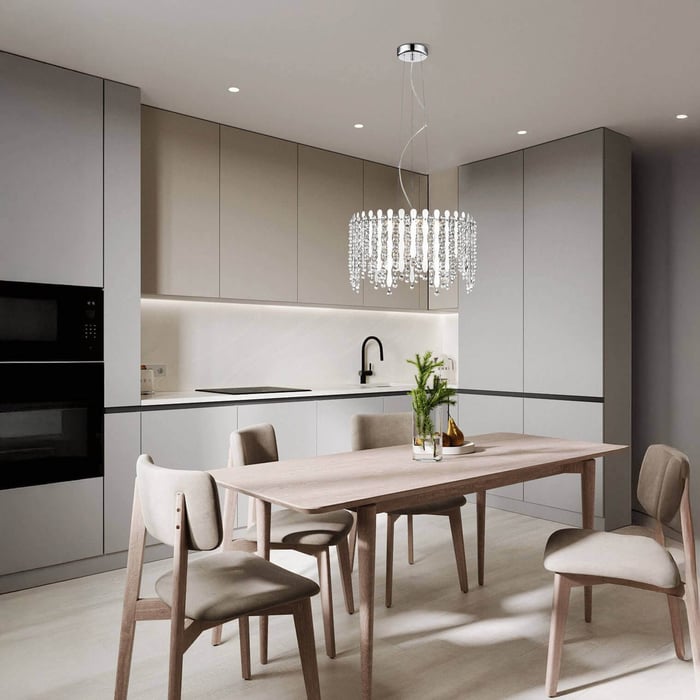 Contemporary kitchen with grey cabinets, wood dining table, and a crystal chandelier centerpiece above the table.