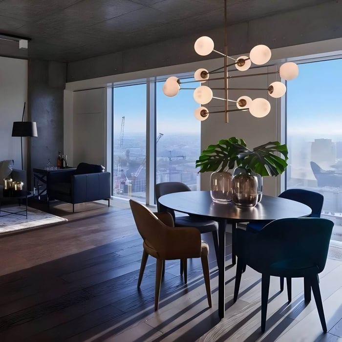 Dining area in high-rise apartment with atomic-style chandelier, round table, velvet chairs, and cityscape views.