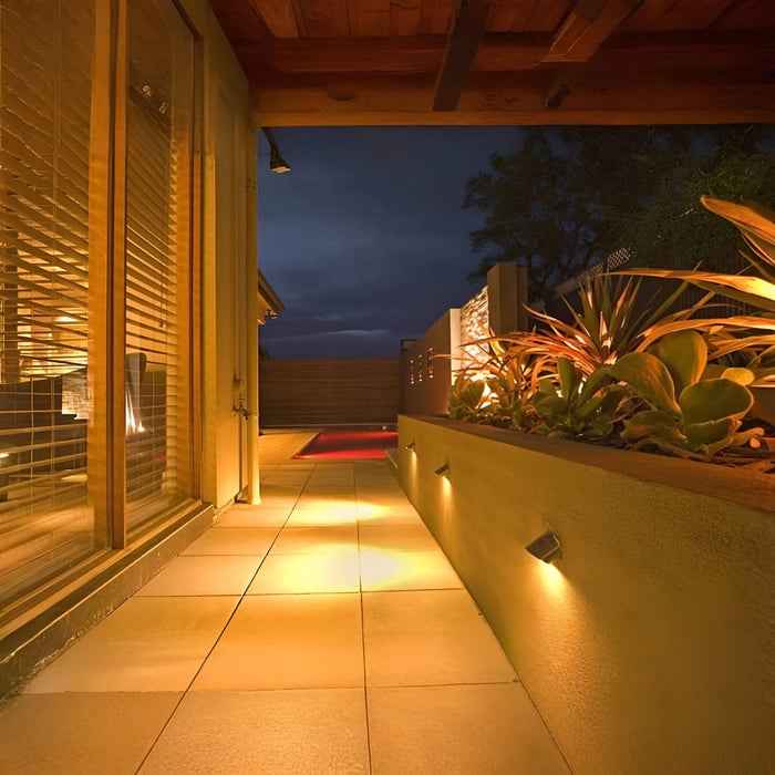 Two black surface-mounted outdoor downlights lighting a minimalist front entrance canopy.