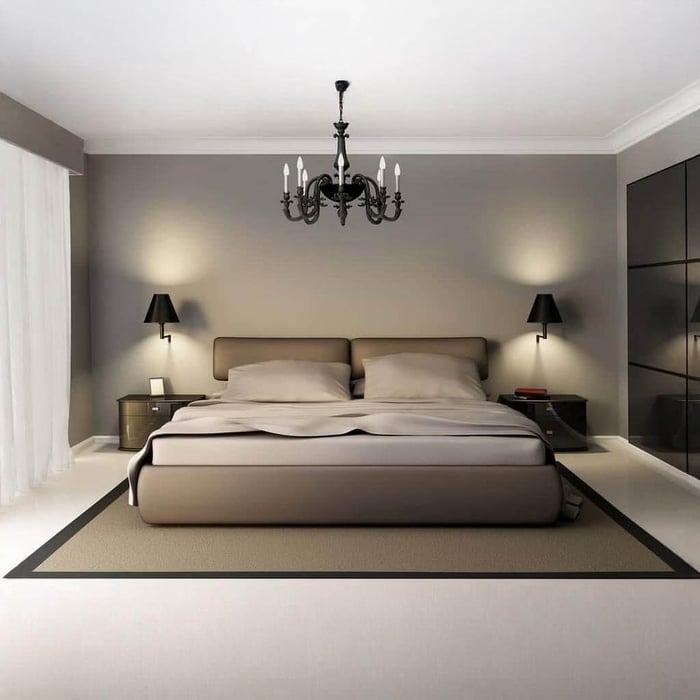 Neutral bedroom with chandelier ceiling light and matching wall sconces beside the bed.