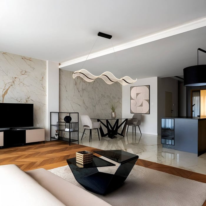 Open-plan living space with sculptural wave pendant light above a circular glass dining table and beige armchairs.