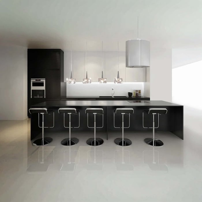 Sleek black-and-white kitchen with a glossy black island, five bar stools, a row of small crystal pendants, and a large white drum pendant.