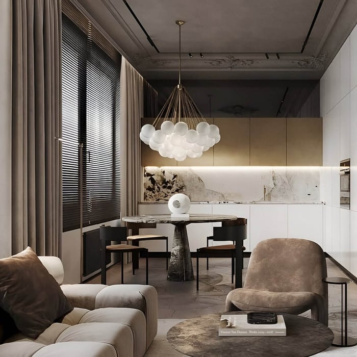 Contemporary dining area featuring white orb cluster chandelier over round marble table.