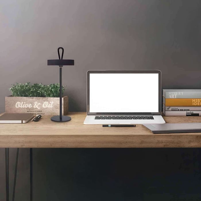 Minimal black table lamp on a home office desk next to a laptop and books, styled in a clean, modern workspace.