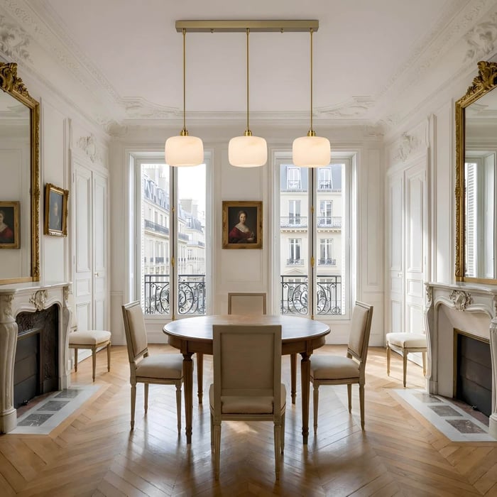 Classic European dining room with three alabaster pendant lights above a round wooden dining table.