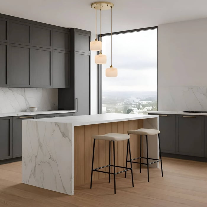 Modern kitchen island with three alabaster pendant lights suspended above a marble countertop.
