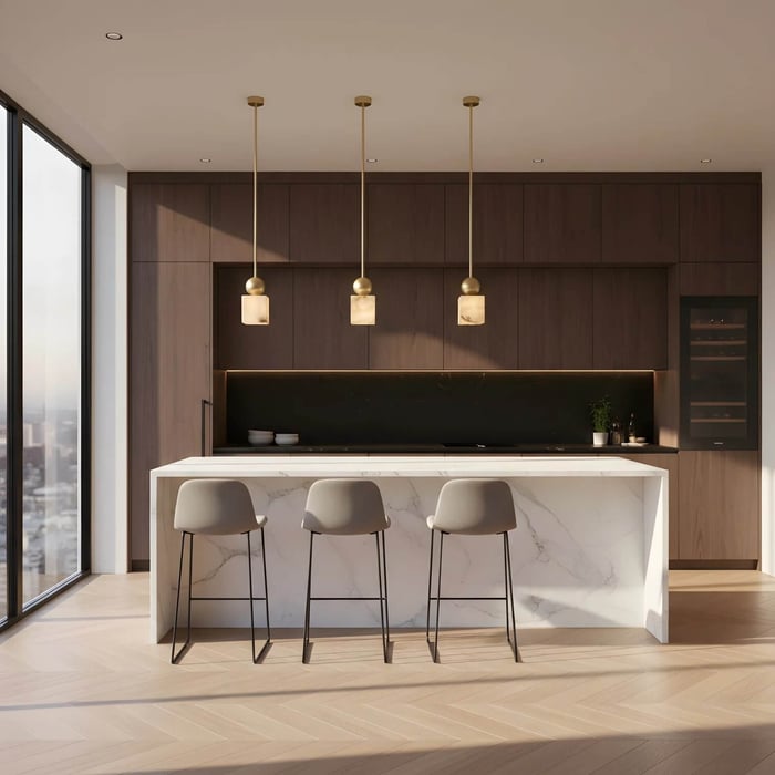 Three cube-shaped alabaster pendant lights with brass stems above a marble kitchen island.