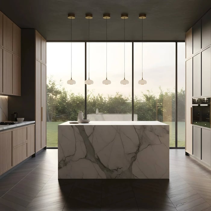 Five small alabaster pendant lights evenly spaced above a marble kitchen island with floor-to-ceiling windows.