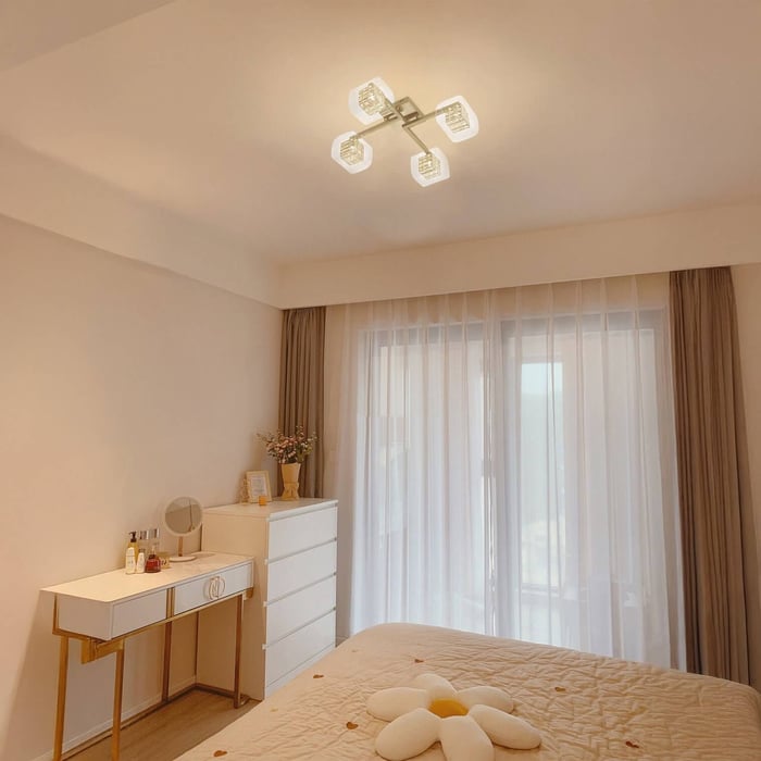 Square four-light ceiling fixture with frosted shades in a bright bedroom.