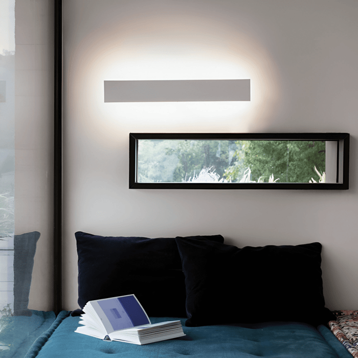 Minimalist rectangular wall light casting upward and downward ambient lighting in a modern living space.