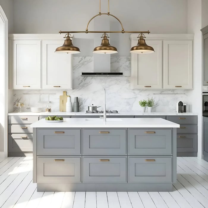 Classic kitchen with a white and gray color scheme, featuring a central island and an overhead fixture with three brass pendant lights in a bar-style arrangement.