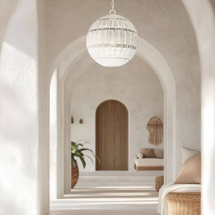 White arched corridor with a large woven globe pendant light and a wooden door in the background.