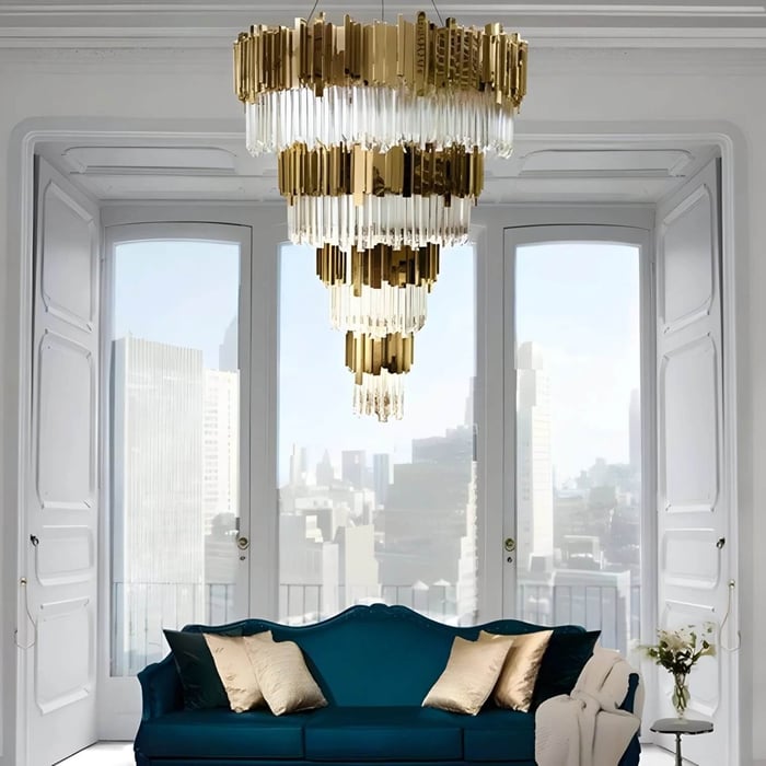 Tiered gold-and-crystal chandeliers hanging in a bright bay-window living room above a teal sofa.