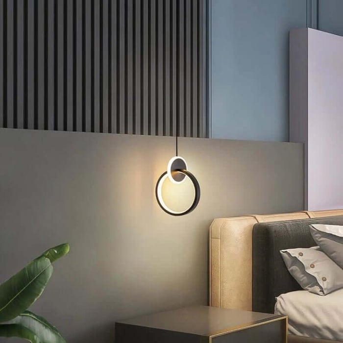 Contemporary bedroom lights with circular ring pendant above bedside table.