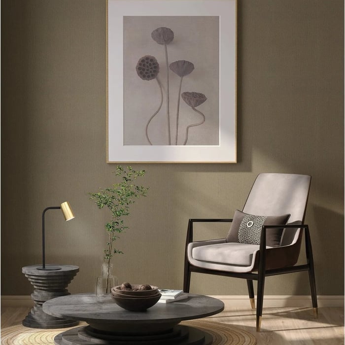 Modern living room scene with a small black-and-gold table lamp on a stone side table beside an armchair.