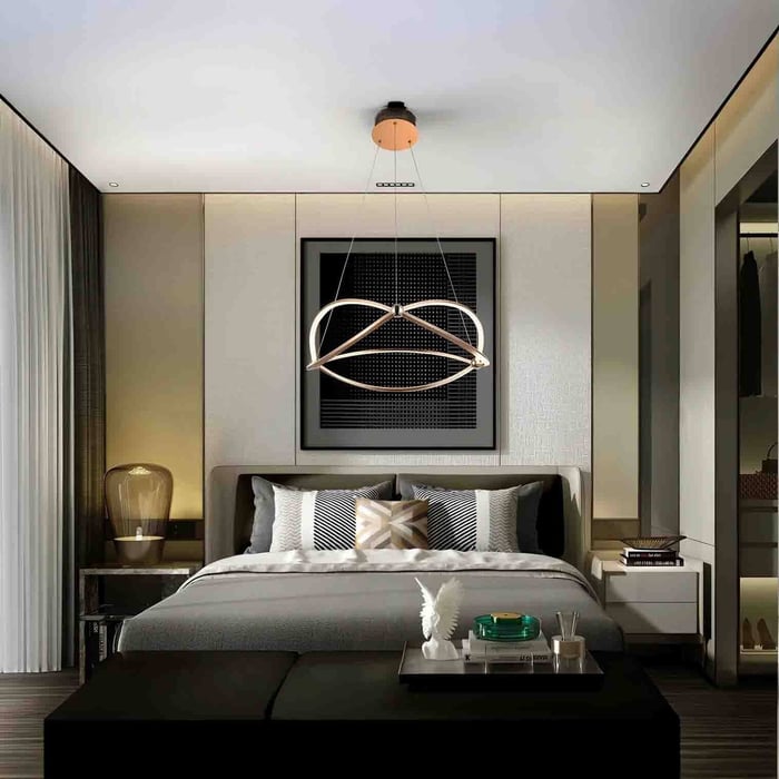 Contemporary bedroom with a sculptural ring pendant light above the bed, styled with neutral wall panels and soft ambient lighting.
