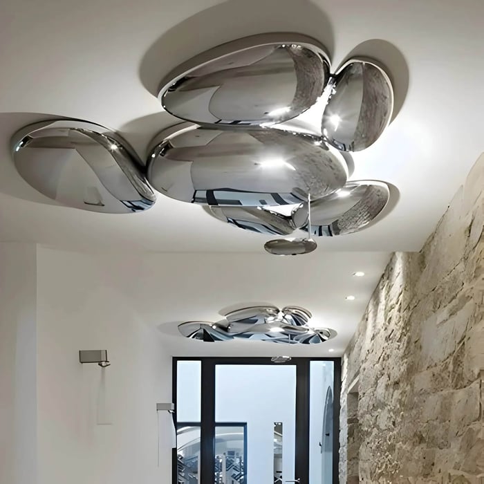 Modern hallway with sculptural chrome LED ceiling lights and stone accent wall.
