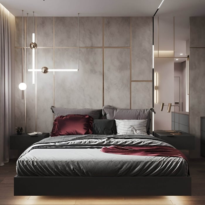Contemporary bedroom with gray panel walls, burgundy pillows, and artistic pendant lighting in brass and frosted glass.