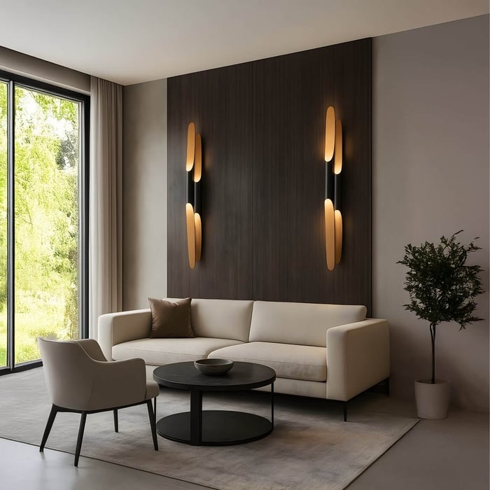 Modern lounge with a beige sofa, black round coffee table, dark wood feature wall, and two vertical ambient wall sconces.