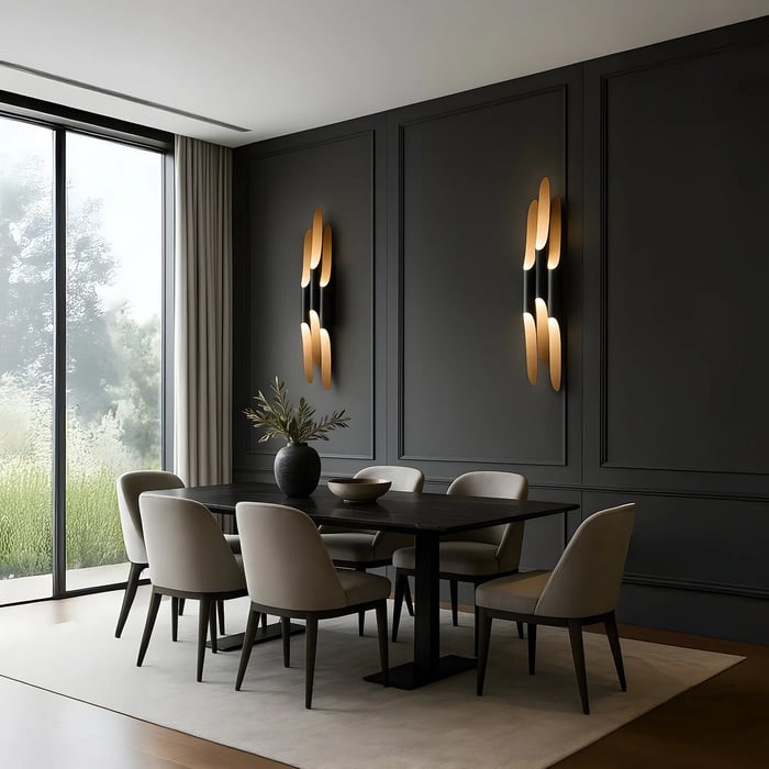 Modern dining room with black paneled walls, gold wall sconces, and a dark rectangular dining table with upholstered chairs.