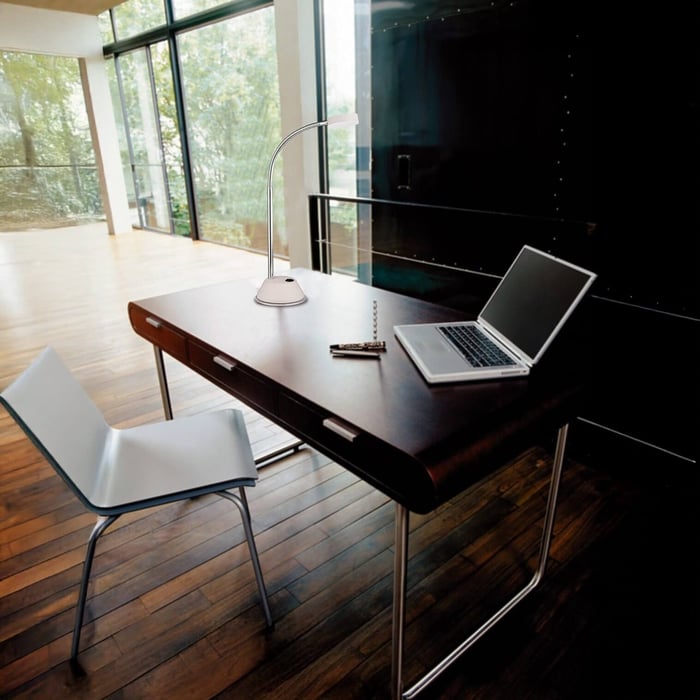 Sleek white LED desk lamp with flexible neck placed on a dark wooden office desk.