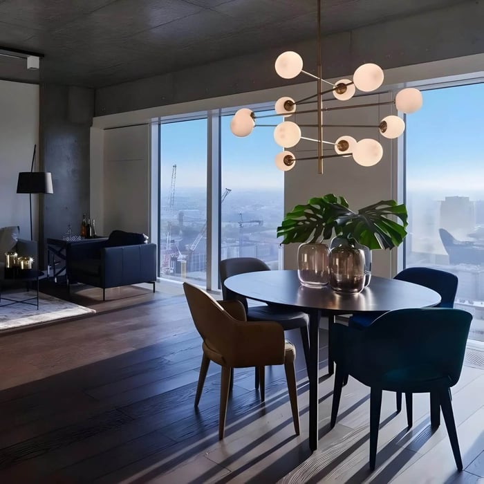 Modern chandelier with frosted globe lights above a round dining table in a high-rise apartment with floor-to-ceiling windows.