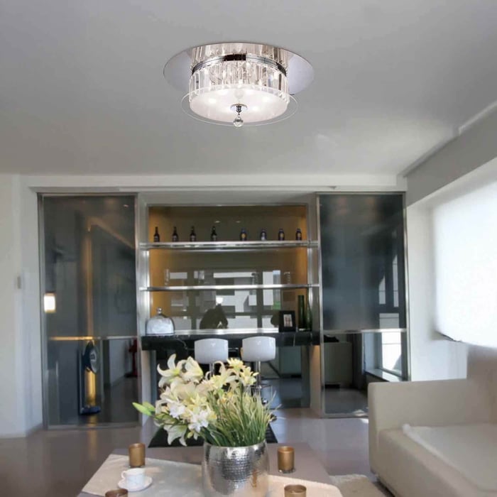 Bright open-plan living area with a round crystal drum ceiling light centred above the room.