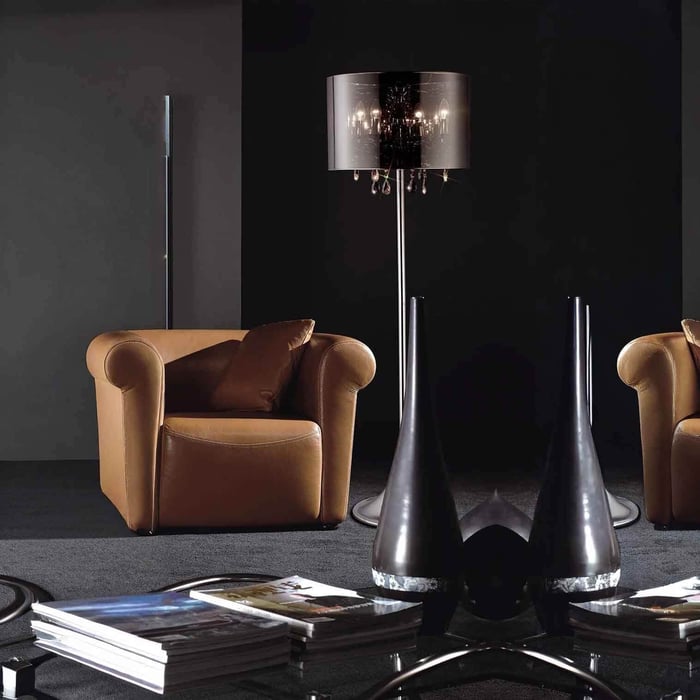 Tall chrome floor lamp with a smoky drum shade and hanging crystal accents in a modern lounge.