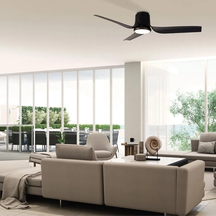 Open-plan lounge with black three-blade ceiling fan light above neutral seating near sliding doors.