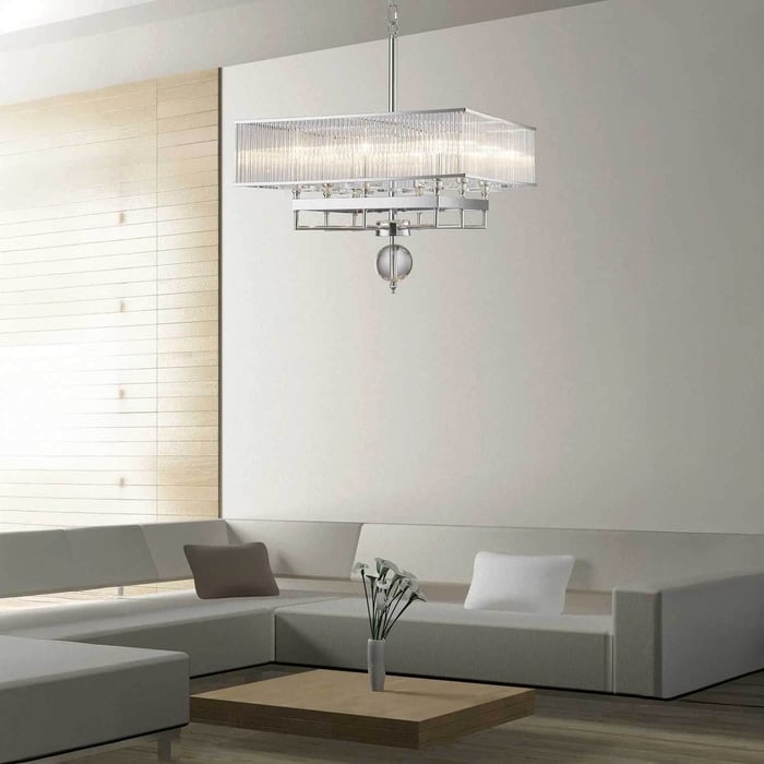 Rectangular crystal chandelier suspended above a modern sectional sofa in a neutral lounge.