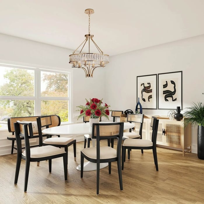 Brass and crystal ring chandelier hanging above a modern dining table with cane chairs.