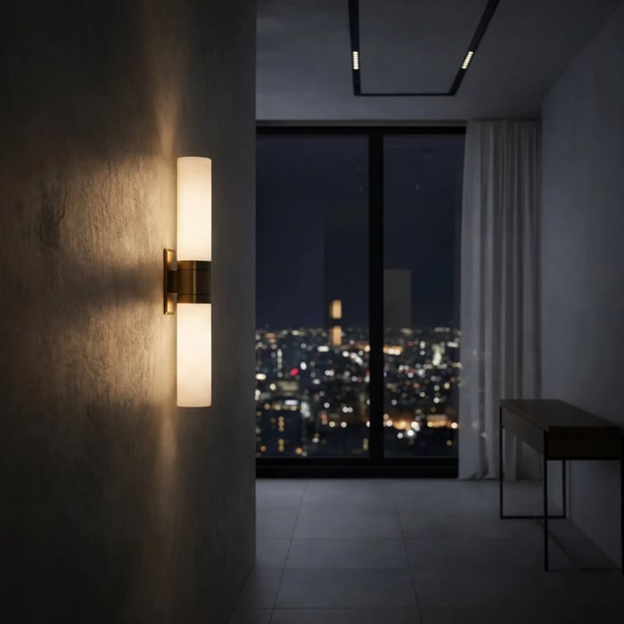 Contemporary hallway at night with city skyline view, featuring a double-ended wall sconce casting warm light on a textured wall.